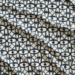 Close up of gently draped fabric with large scale geometric lattice design in cream and navy blue.