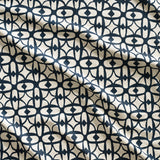 Close up of gently draped fabric with large scale geometric lattice design in cream and navy blue.