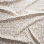 Close up of gently draped fabric with large scale geometric lattice design in white and ecru.