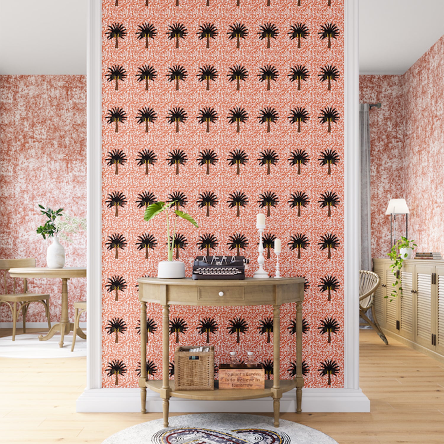 A maximalist living space with an accent wall papered in a repeating palm tree print on a mottled white and coral field.