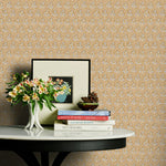 Decorative table with books and flowers against a brown and blue floral wallpaper.