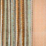 Patterned fabric with vertical stripes and geometric designs in brown, green, and beige.