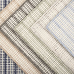 Broadloom carpet  samples stacked in a range of colors in a textural strie stripe.