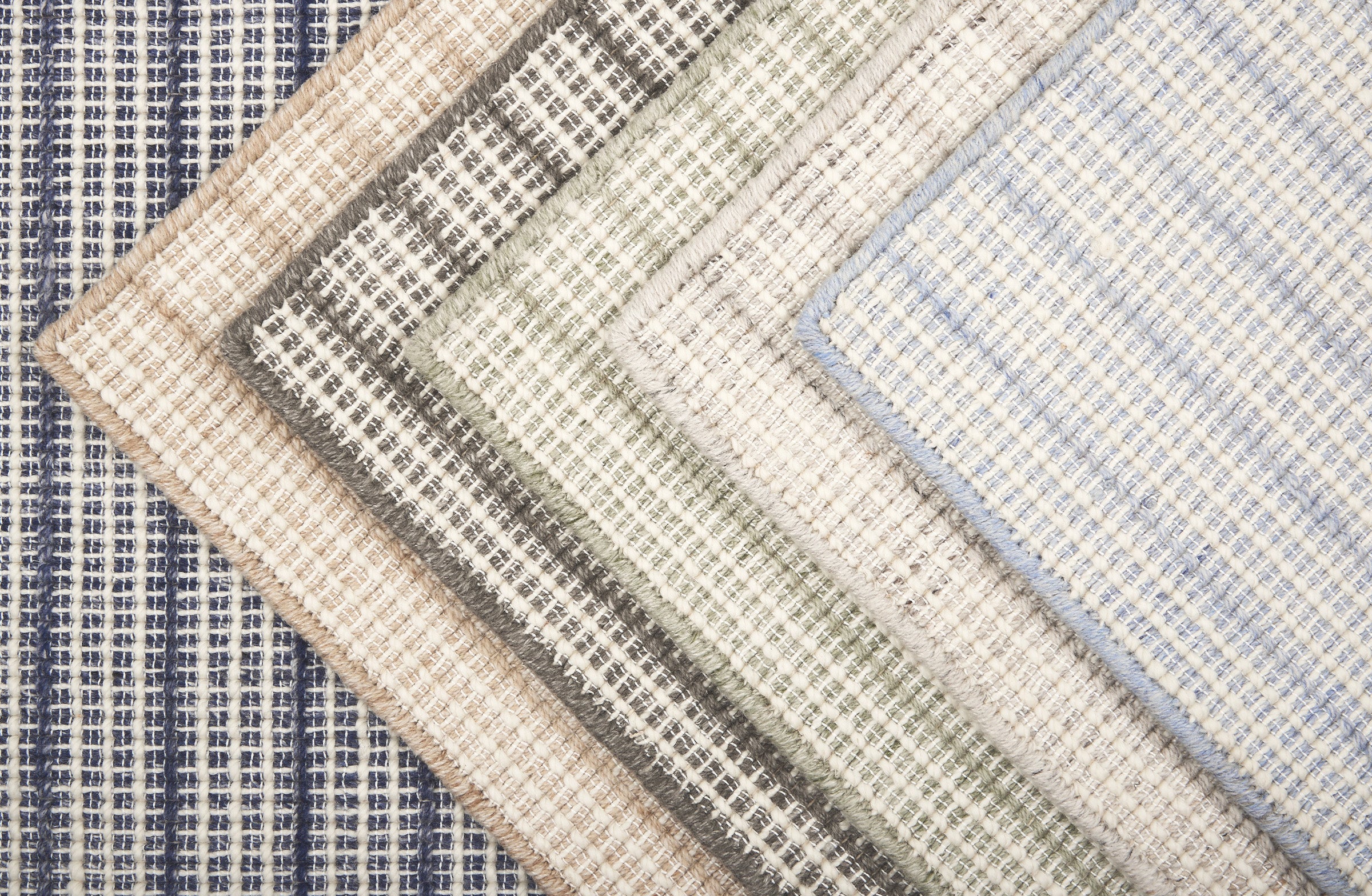 Broadloom carpet  samples stacked in a range of colors in a textural strie stripe.