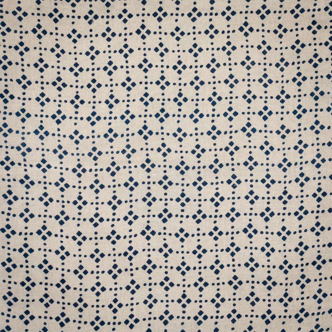 Block printed fabric in a dotted lattice in indigo on natural linen.