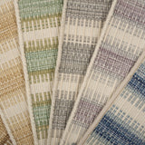 Broadloom carpet samples spread in an arc in a striped pattern in a range of colors. 