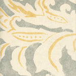 Detail of wallpaper in a floral damask print in light yellow and gray on a cream field.