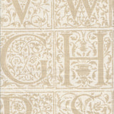 Detail of fabric in a playful alphabet grid print in tan on a cream field.