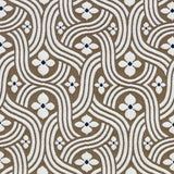Detail of fabric in a floral damask print in white and black on a brown field.
