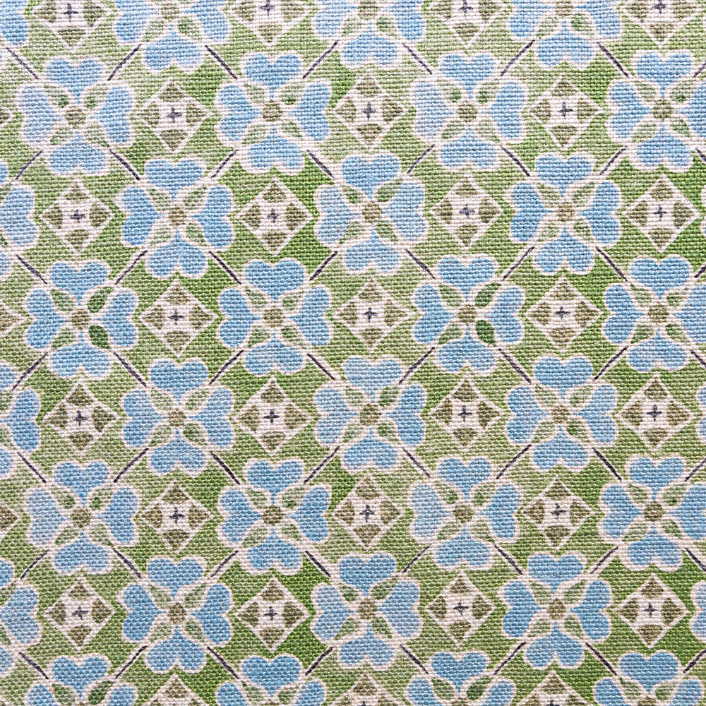 Detail of fabric in a floral lattice print in blue, green, brown and white.
