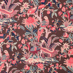Printed fabric with a lush botanical motif with exotic birds in pink, blue and white on a brown field. 