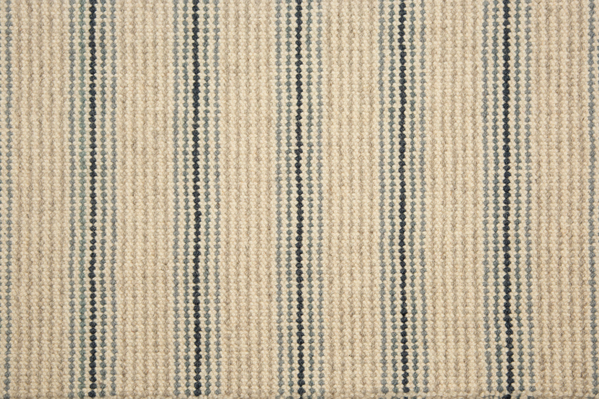 Broadloom carpet with widely spaced pin stripes in light and dark blue with oatmeal. 