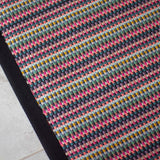Striped flatweave runner in pink green purple blue with black border 