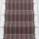 Striped flatweave runner in pink green purple blue with black border on white staircase
