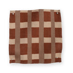A fabric swatch in a gridded check pattern in brick red, clay and cream. 
