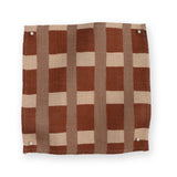 A fabric swatch in a gridded check pattern in brick red, clay and cream. 