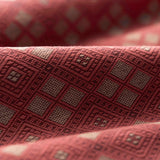 Close-up of textured fabric with a geometric pattern in shades of red.