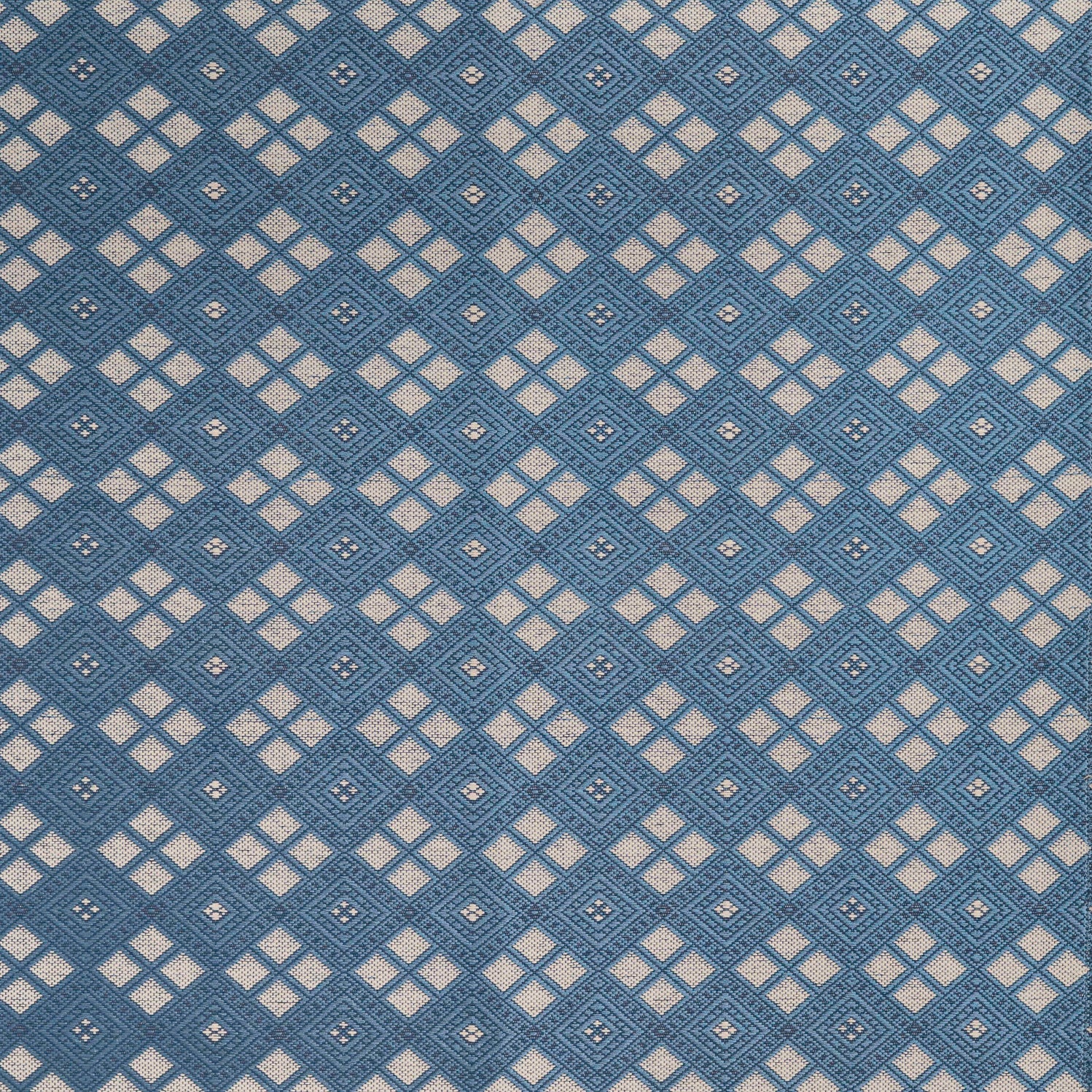 Woven fabric with ornate diamond design with cream accents on blue.