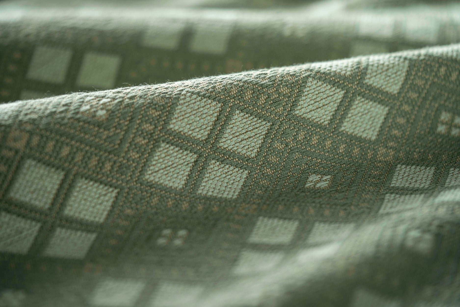 Close-up of textured fabric with geometric pattern in green