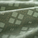 Close-up of textured fabric with geometric pattern in green