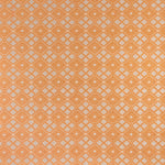 Woven fabric with ornate diamond design with cream accents on orange. 