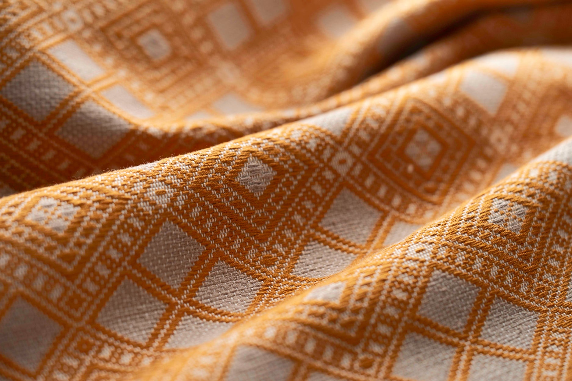 Close-up of textured yellow and white fabric with geometric pattern