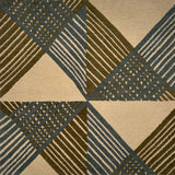 Close-up of a geometric patterned rug with triangles and stripes in green and blue.