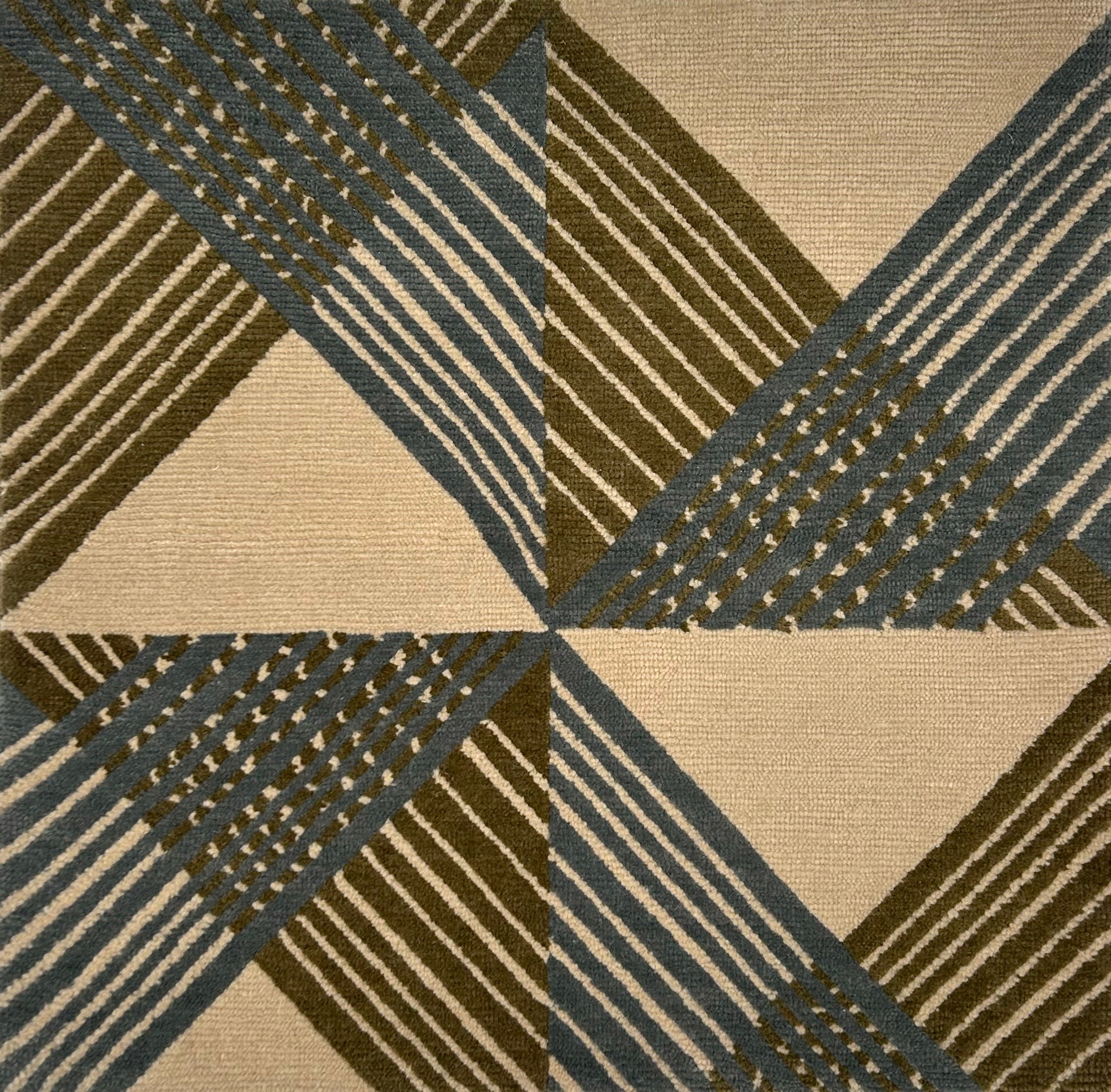 Close-up of a geometric patterned rug with triangles and stripes in green and blue.