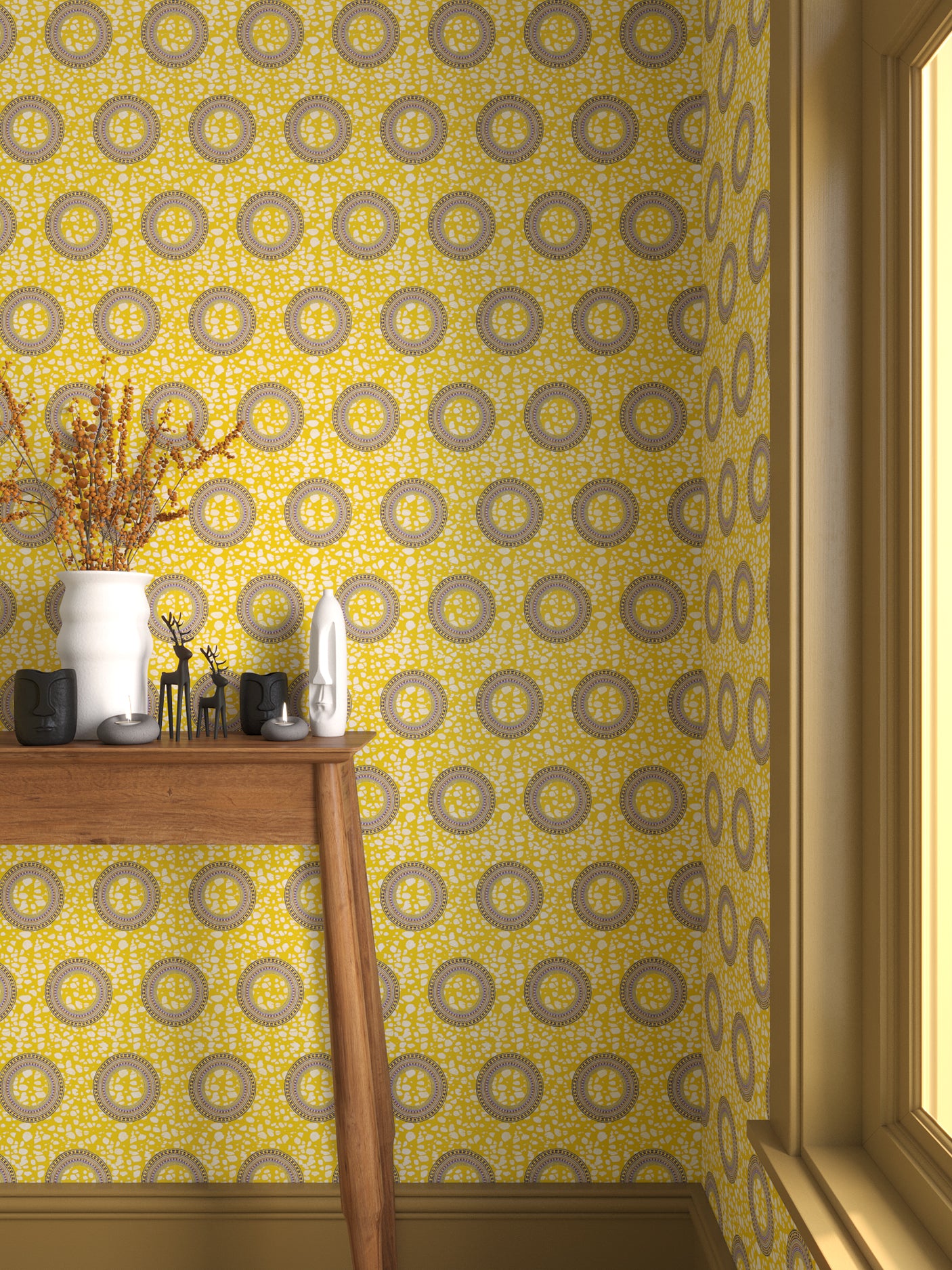 Interior with bright yellow circle printed wallpaper and matching trim with a wooden console table with white ceramic vases and mini ceramic sculptures. 