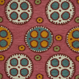 Flatweave rug with a playful polka dot pattern with a mix of sizes in cream and yellow with red outlines and smaller blue, yellow and green dots on a pink field. 