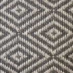 Close-up of a textured natural fibre woven diamond pattern rug in grey. 