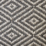 Close-up of a textured natural fibre woven diamond pattern rug in grey. 