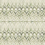 Detail of fabric in a painterly ikat print in shades of green on a white field.