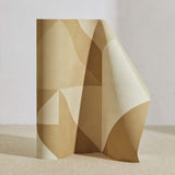 A curved partition stands on the ground, covered in a large-scale geometric print in cream and tan.