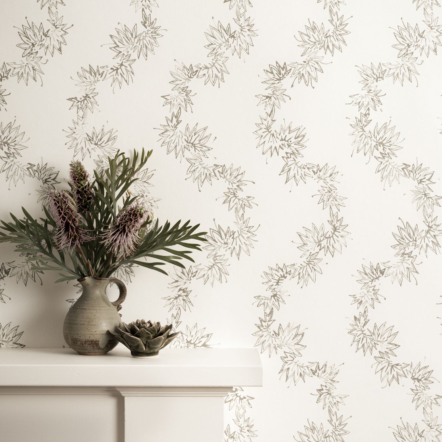 Mantle with vase against wallpaper with stylized leaf stripe. 