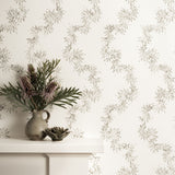 Mantle with vase against wallpaper with stylized leaf stripe. 