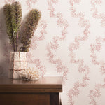 Decorative wallpaper with floral pattern and a wooden table with plants.