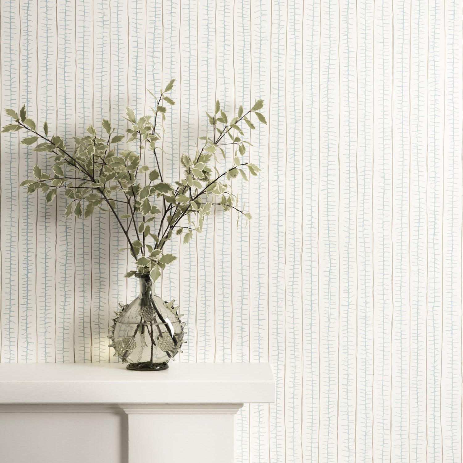 Decorative wallpaper with a subtle pattern, a vase with greenery on a white mantle