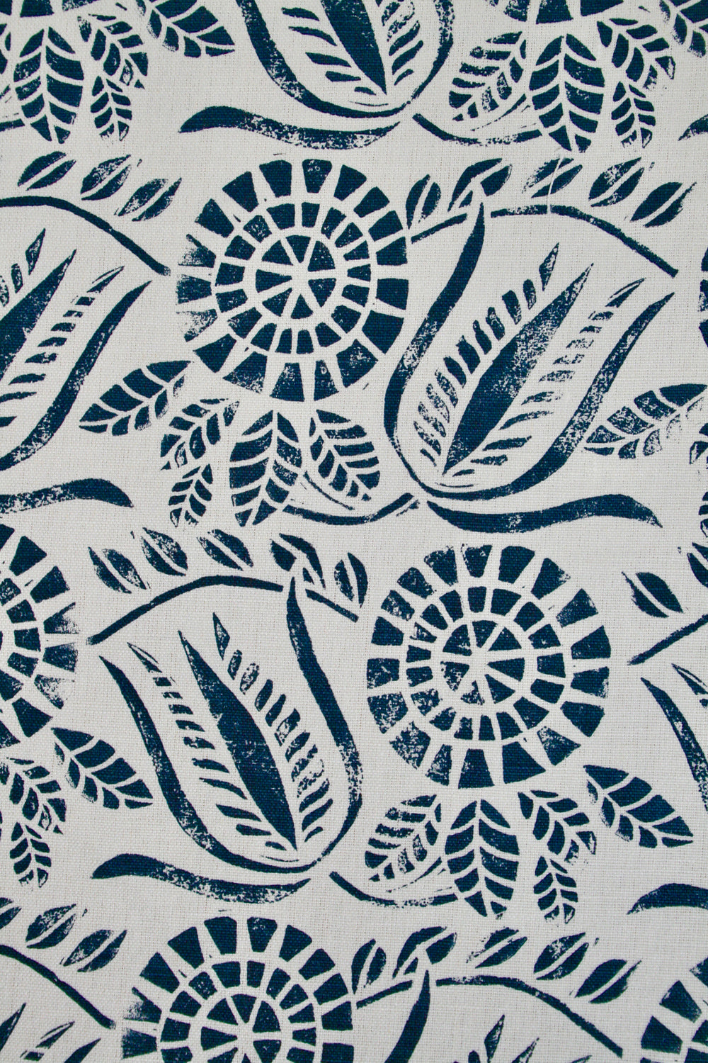 Close-up of fabric in a dense floral print in navy on a white field.