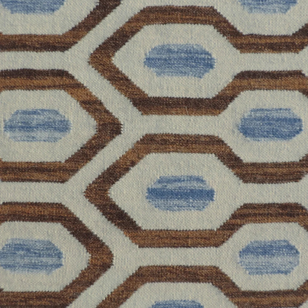 Close-up of a patterned rug with blue and brown geometric design