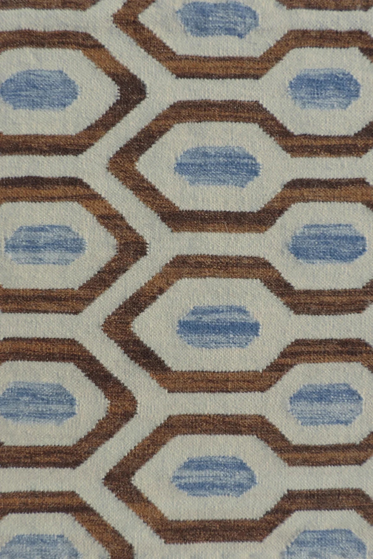 Close-up of a patterned rug with blue and brown geometric design