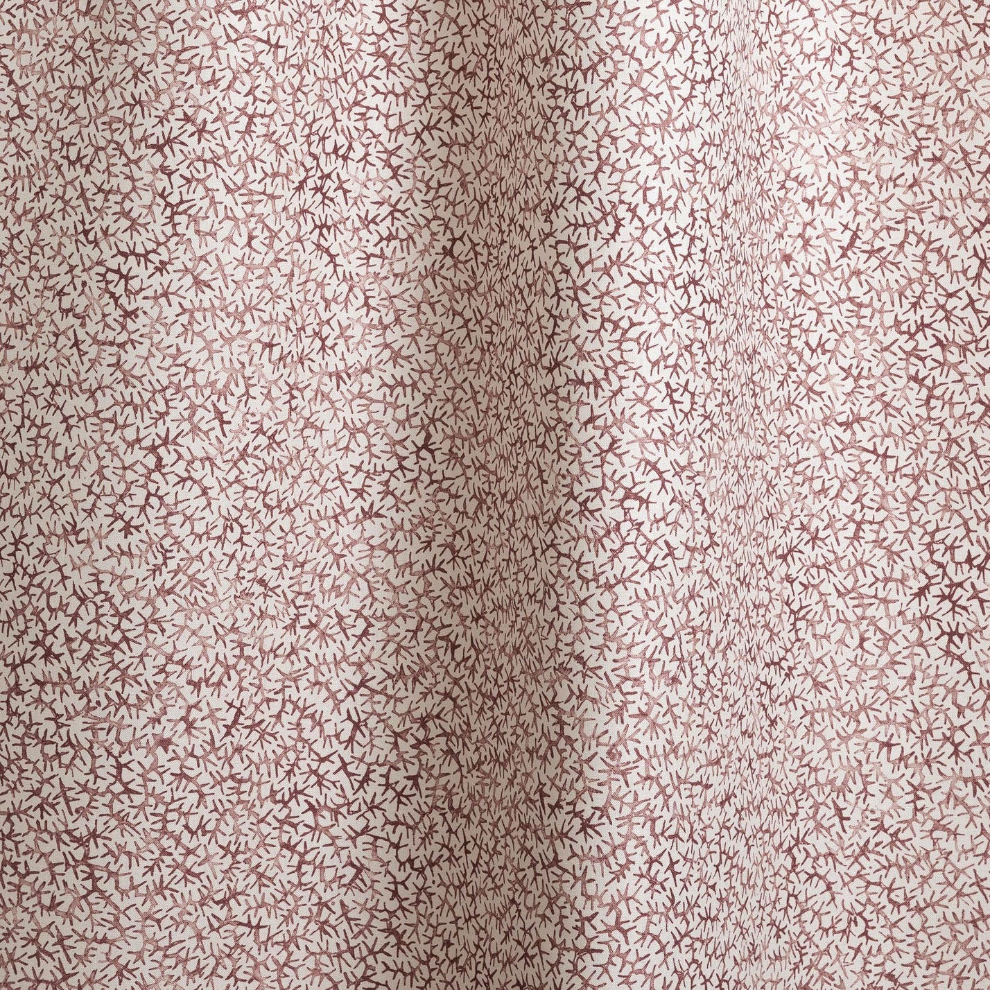 Draped fabric with small scale coral design in wine-red on white. 