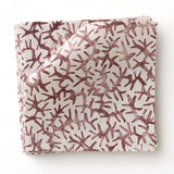 Fabric swatch with small scale coral design in wine red on white. 
