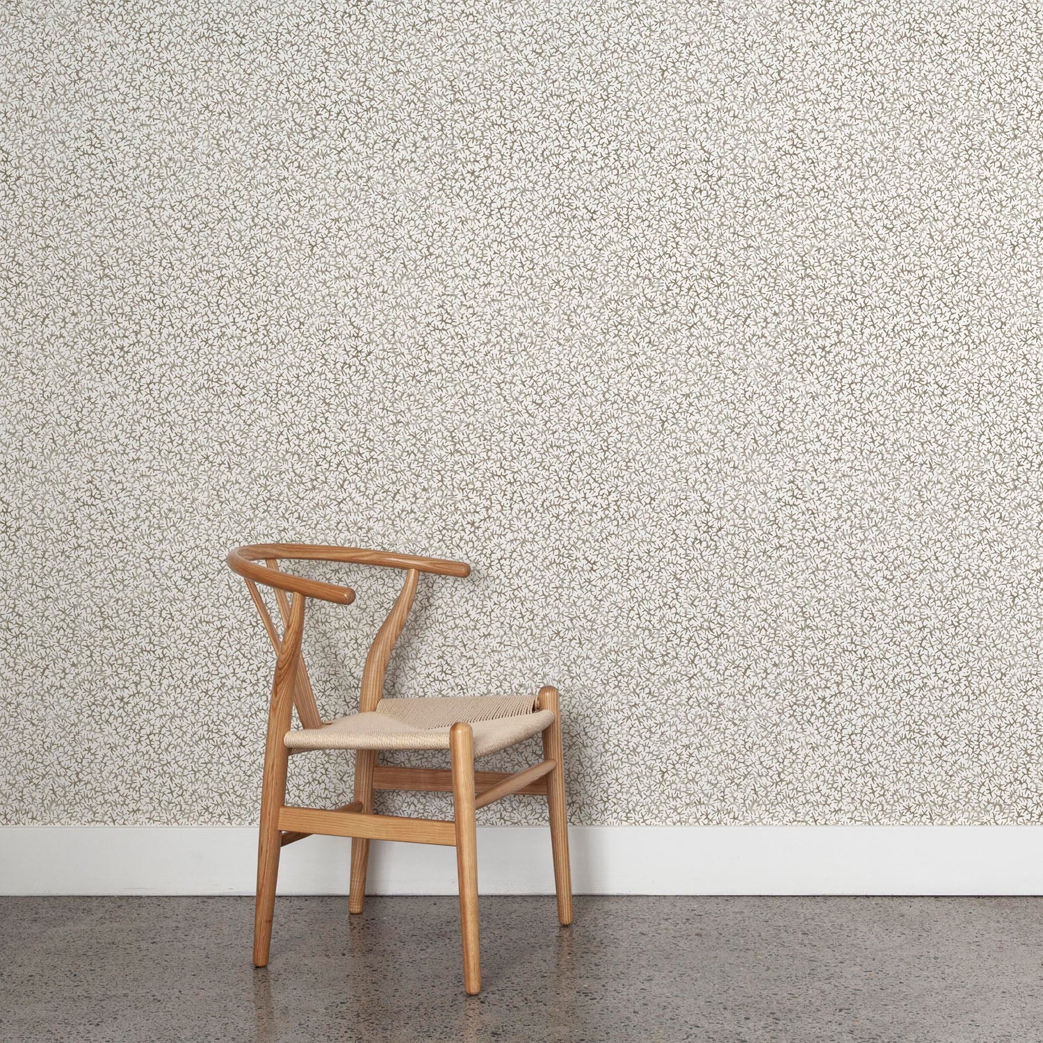 Wooden chair against a patterned grey watercolor wallpaper wall