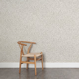 Wooden chair against a patterned grey watercolor wallpaper wall