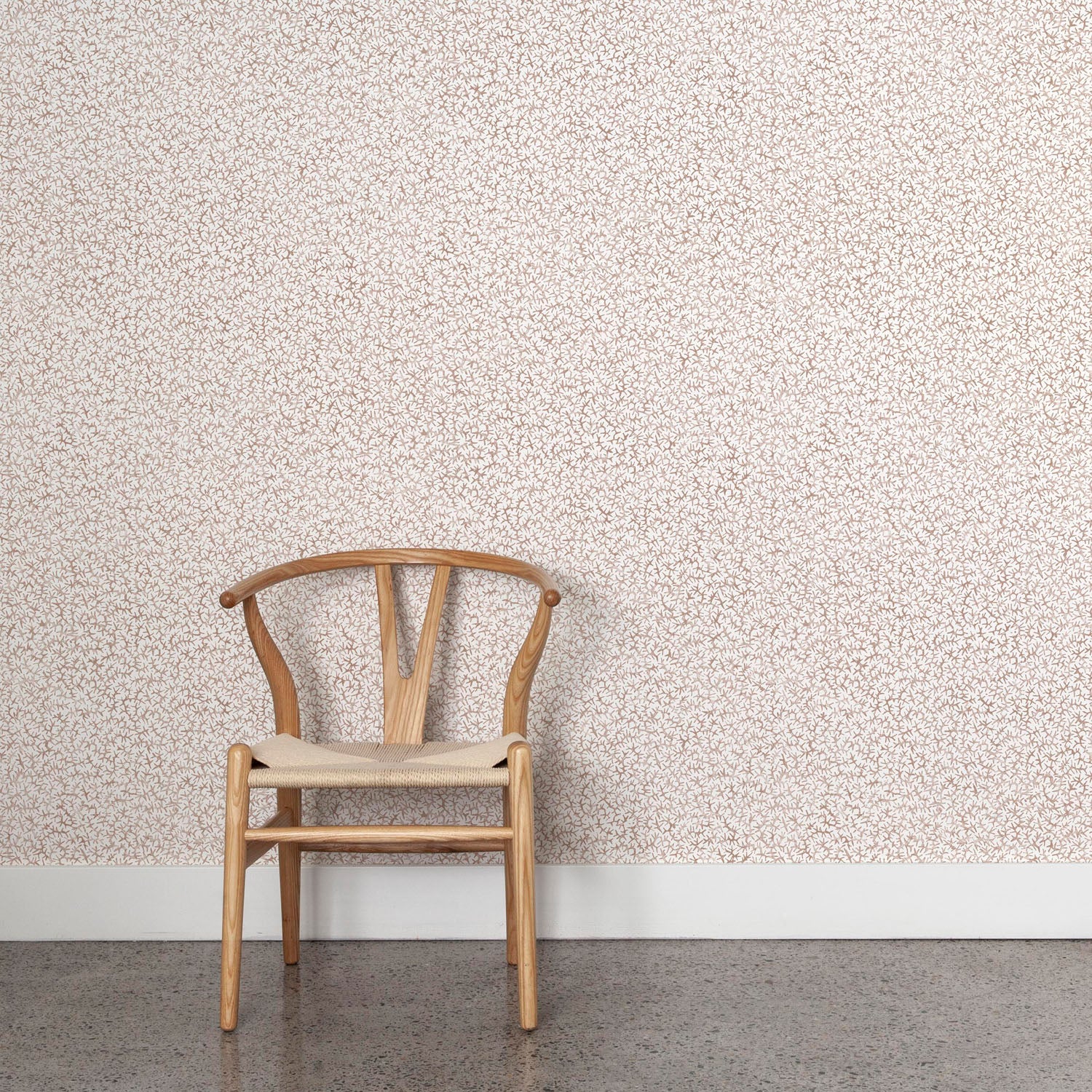 Wooden chair against a coral watercolor wallpaper. 