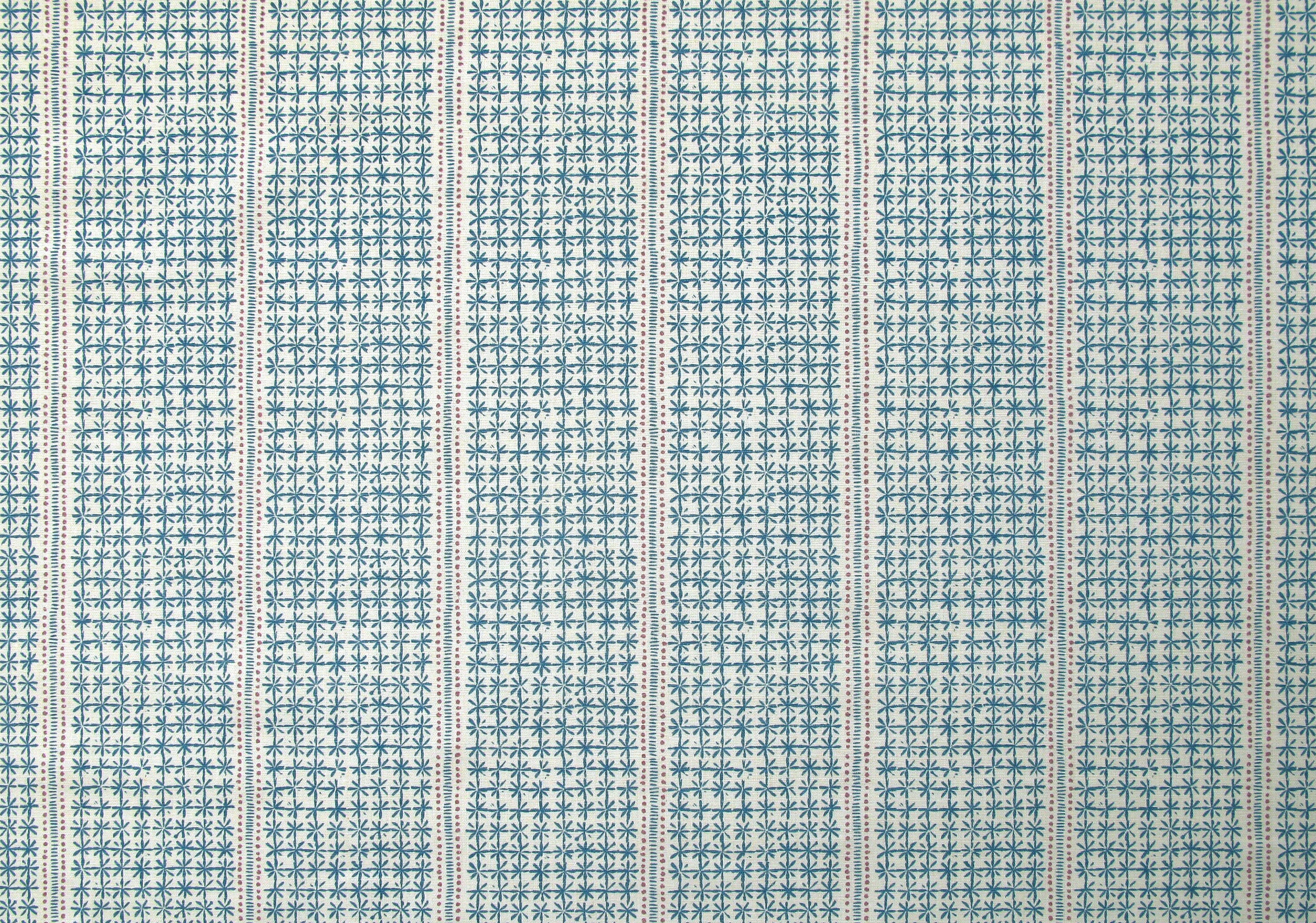 Detail of fabric in a dense repeating stripe and star print in blue on a cream field.