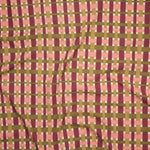 Close up of printed linen with graphic plaid pattern in pink, magenta, tan and olive green. 