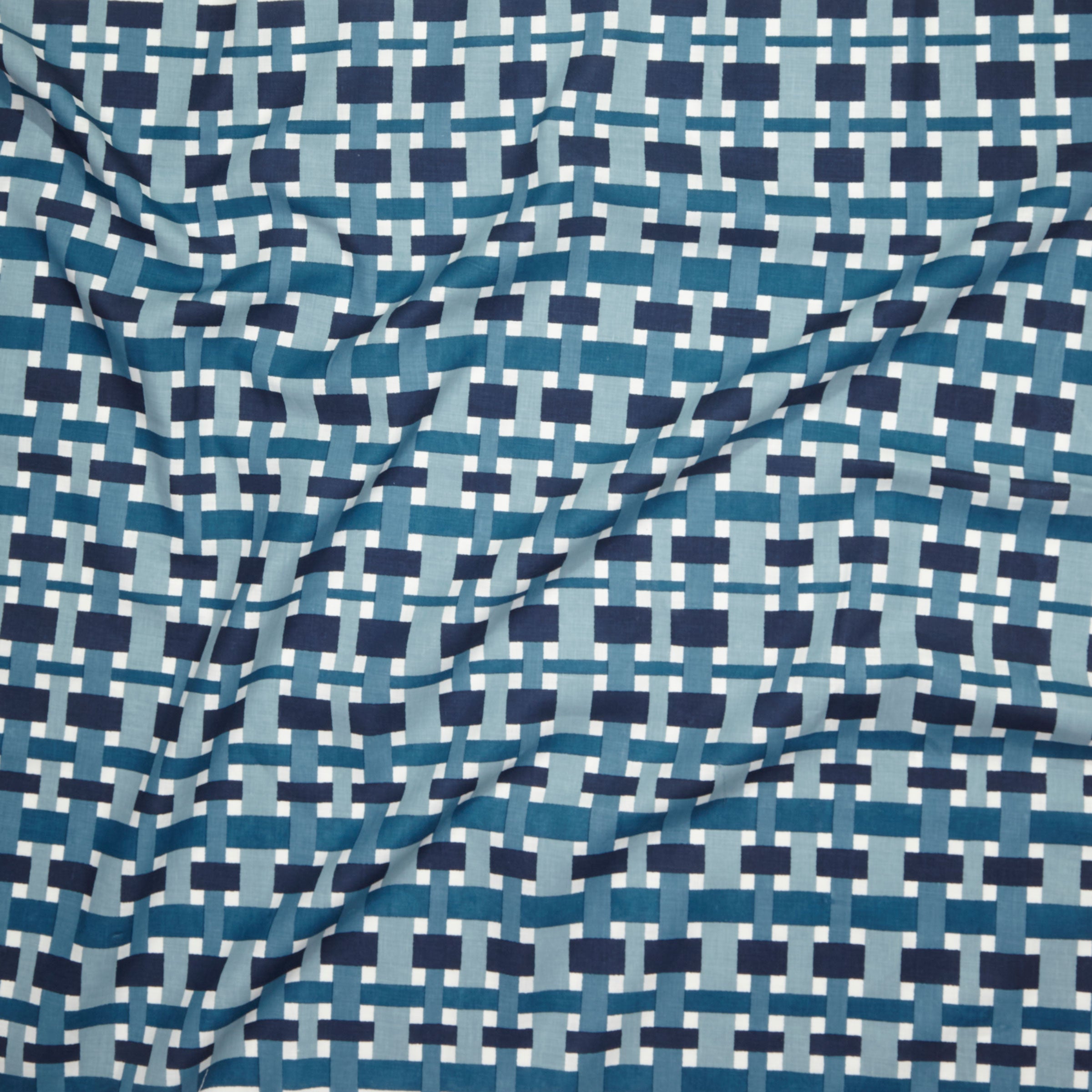 Close up of printed linen with graphic plaid pattern in shades of light blue, denim and navy blue.