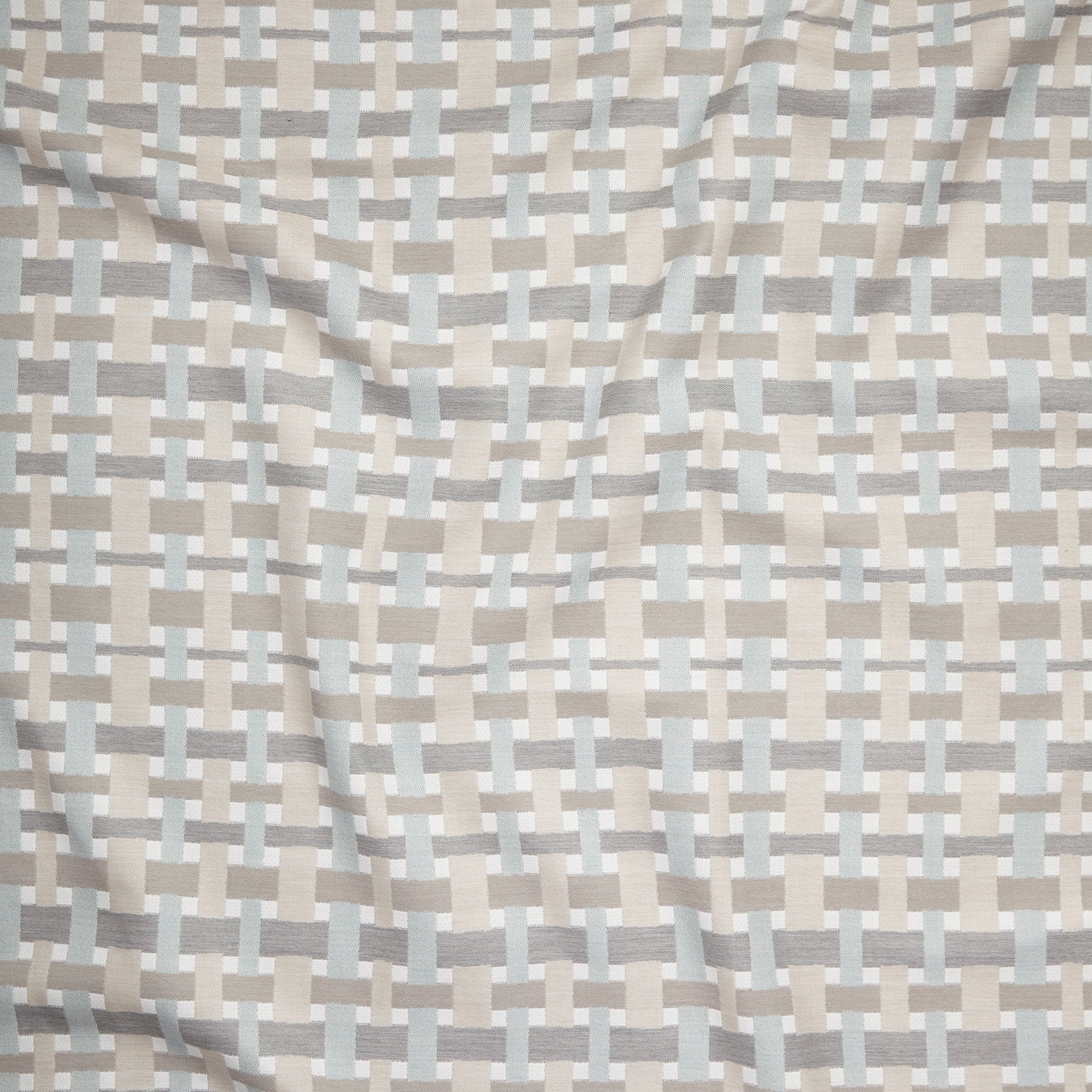 Close up of gently draped woven Indoor-Outdoor fabric with graphic plaid pattern in neutral tones. 